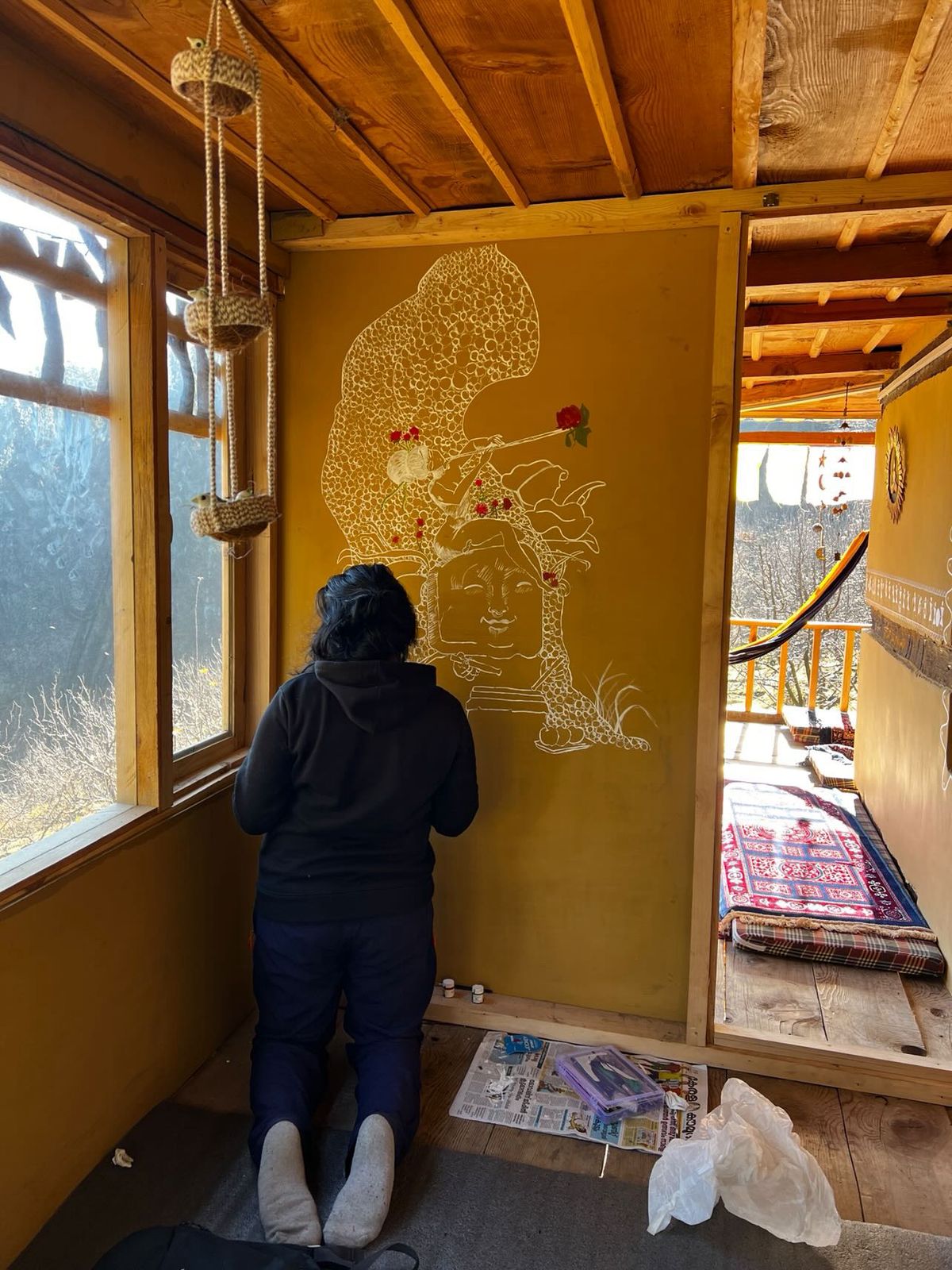 Artist painting Krishna mural inside base